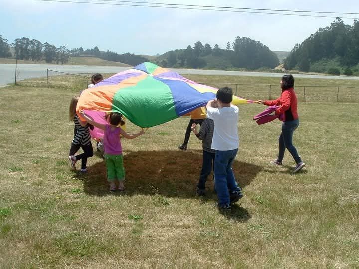 Children playing with a parachute in the field